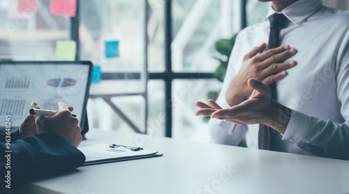 Принти на полотні Business Meeting: A serious conversation between two business professionals at a desk, focused on a laptop screen with data