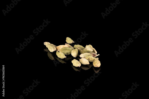 dry cardamone seeds as condiment isolated on black background