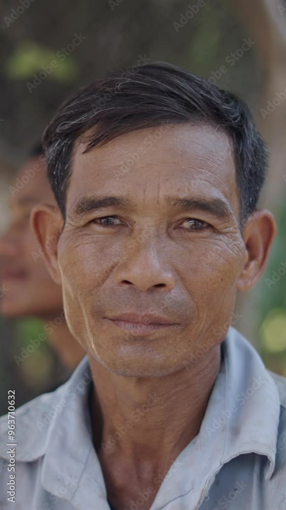 portrait of a mature asian man with a very sucai shirt and reeds in his hair looking at camera in vietnam portrait of a mature asian man with a very sucai shirt and reeds in his hair looking at camera in vietnam