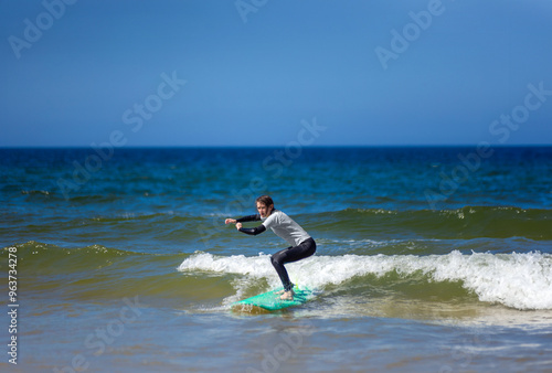 Canvas Print Teenage girl learning to surf on foam in the ocean