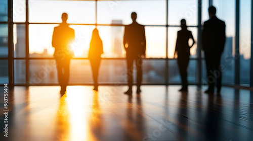 Silhouettes of Business People Looking Out Window at Sunset