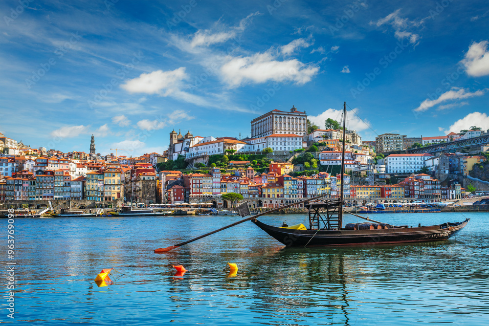 Fototapeta premium View of Porto city and Douro river with traditional boats with port wine barrels ship from famous tourist viewpoint Marginal de Gaia riverfront. Porto, Vila Nova de Gaia, Portugal