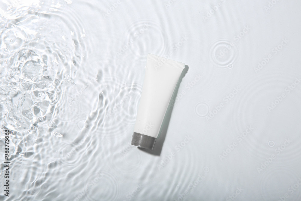 Cosmetic product. Tube with cream in water on light background, top view Cosmetic product. Tube with cream in water on light background, top view