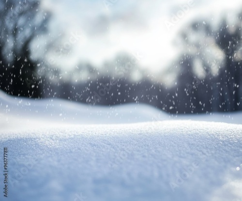 Snowy landscape with soft snowdrifts and gentle falling snow, set against a blurred background of winter trees and a cloudy sky