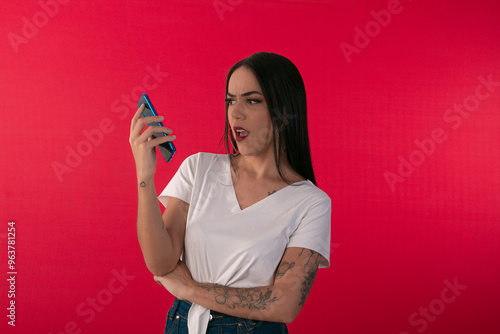 Young woman with smartphone simulating use with facial expressions. photo