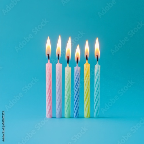 Colorful Row of Lit Birthday Candles on a Blue Background