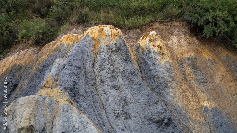 A rocky hillside with a yellow and gray color pattern A rocky hillside with a yellow and gray color pattern