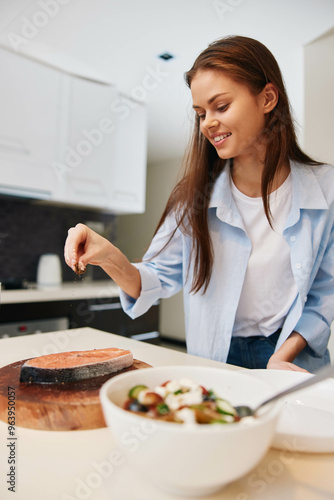 Happy woman cooking in her home kitchen, enjoying preparing delicious food for her family and friends