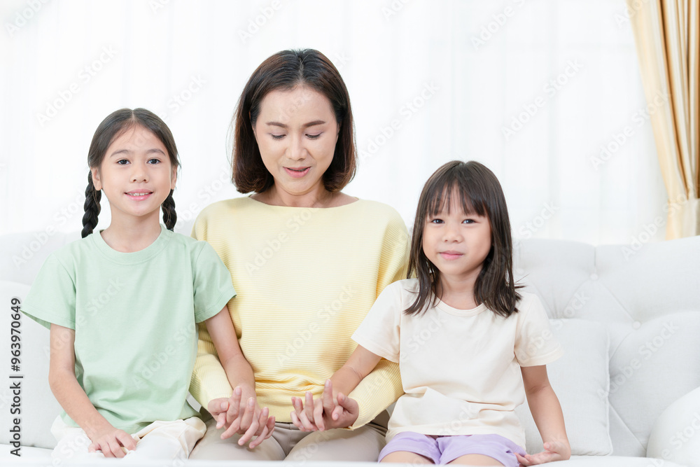 Asian mother and daughter sitting on sofa in living room Asian mother and daughter sitting on sofa in living room
