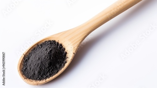 Fine black powder on a wooden spoon showcasing natural ingredients for home remedies and cooking photo