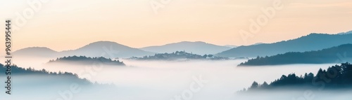 A serene landscape featuring soft hills shrouded in mist, creating a tranquil atmosphere at dawn.