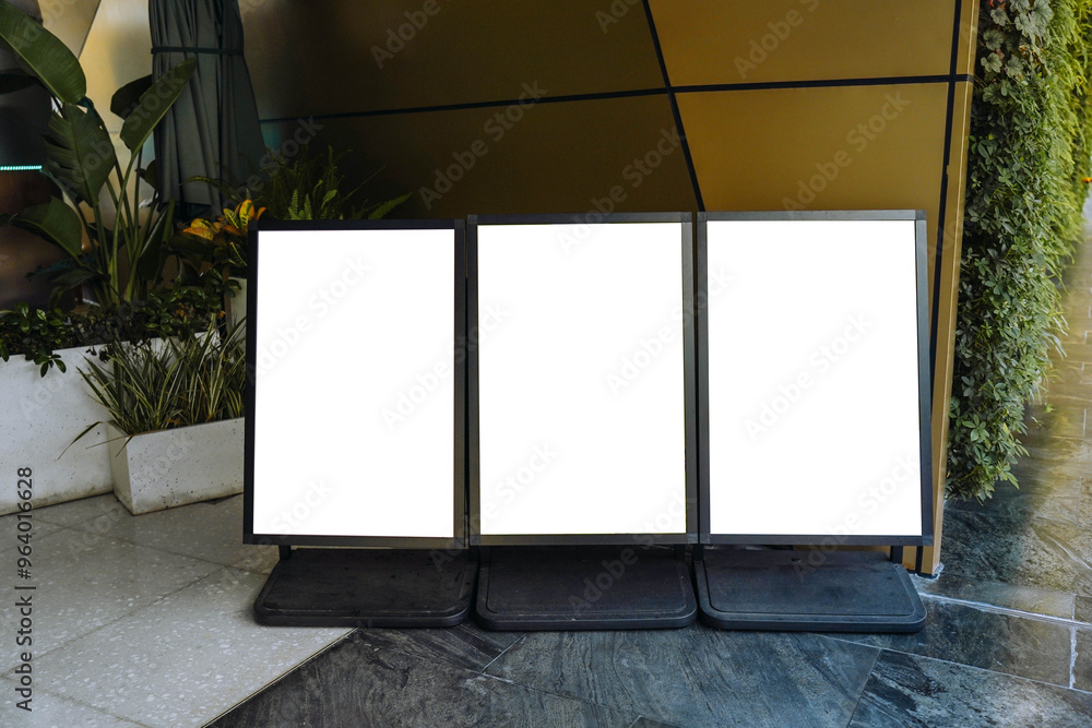 Blank white outdoor advertising stand or sandwich board mock up template. Clear street signage board placed by an outdoor dinning area of a restaurant. Background texture of standee on street.