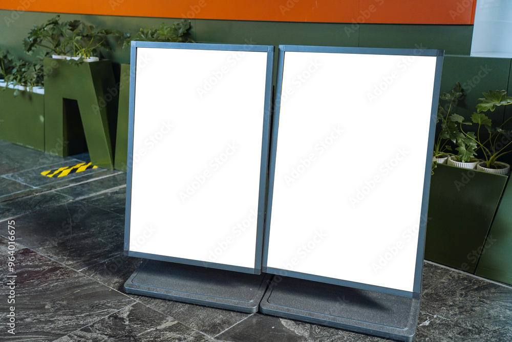 Blank white outdoor advertising stand or sandwich board mock up template. Clear street signage board placed by an outdoor dinning area of a restaurant. Background texture of standee on street.