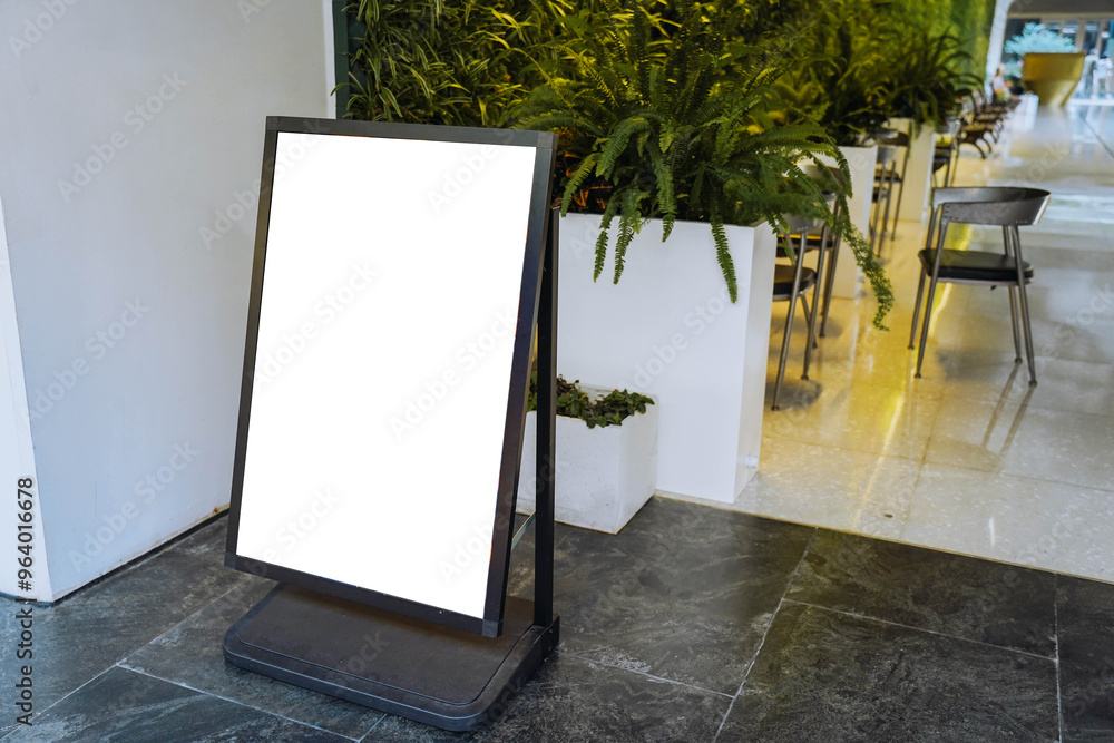 Blank white outdoor advertising stand or sandwich board mock up template. Clear street signage board placed by an outdoor dinning area of a restaurant. Background texture of standee on street.