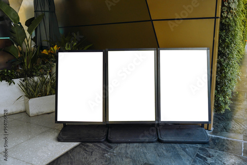 Obraz na płótnie Blank white outdoor advertising stand or sandwich board mock up template. Clear street signage board placed by an outdoor dinning area of a restaurant. Background texture of standee on street. w salonie
