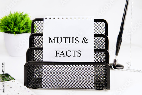 Business, finance and fact vs myth concept. Fact vs myth symbol. Concept words Fact and myth on a white sheet of paper in a stationery stand on a white background photo