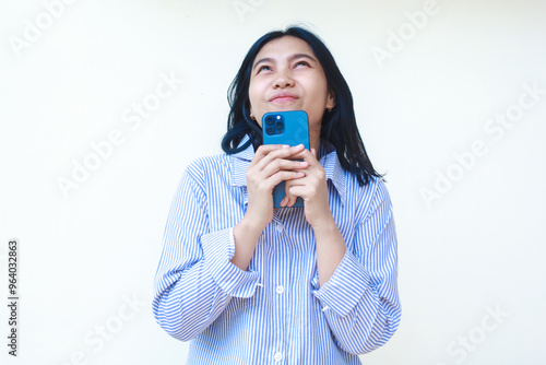 happy asian woman using smartphone surfing in social media cyberspace wearing striped shirt isolated on white background