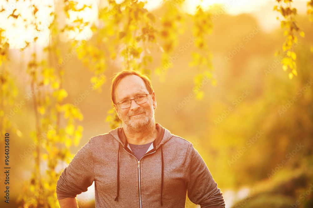 Outdoor portrait of 50 - 55 year old man enjoying nice bright morning or evening in rays of light Outdoor portrait of 50 - 55 year old man enjoying nice bright morning or evening in rays of light