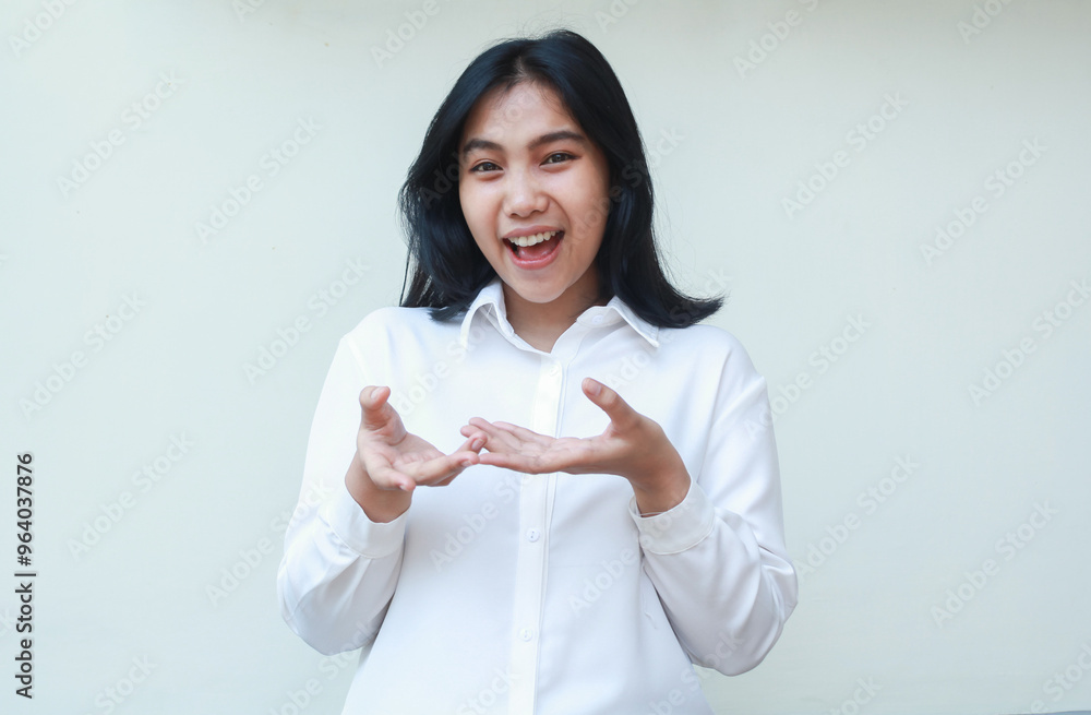 playful succes asian young business woman excited raising hands palms showing imaginary product with happiness face expression wearing white formal suit shirt isolated on white background playful succes asian young business woman excited raising hands palms showing imaginary product with happiness face expression wearing white formal suit shirt isolated on white background
