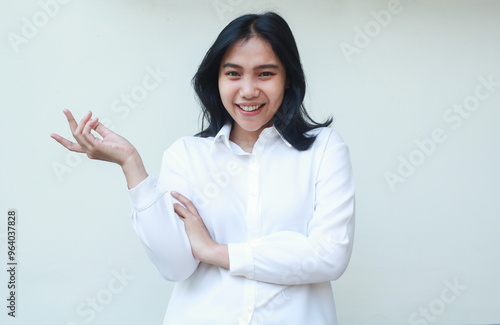 successful asia young business woman manager raising open palms to beside blank space and folded arms look at camera with confident smile wearing white formal suit shirt isolated in whte background