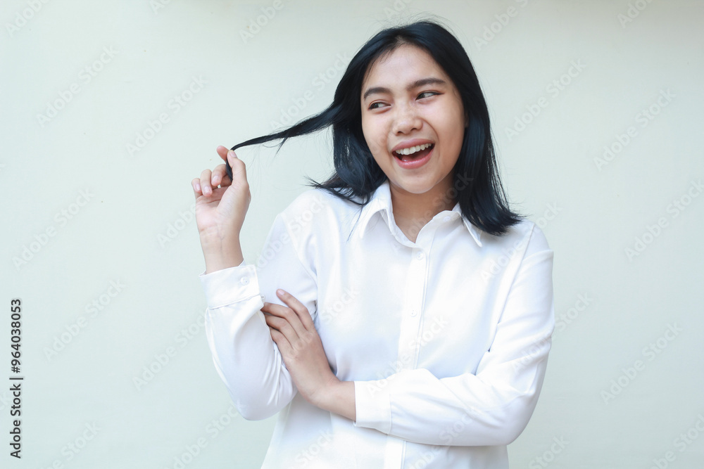 portrait of carefree asian young business woman grabbing her dark hair with arms folded looking aside imagine, wearing white formal suit shirt standing over isolated background portrait of carefree asian young business woman grabbing her dark hair with arms folded looking aside imagine, wearing white formal suit shirt standing over isolated background