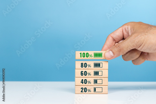 100%, Make an assessment, Confidence, Maximum efficienc. A man putting wooden cube with number 100 percent on table in the office photo