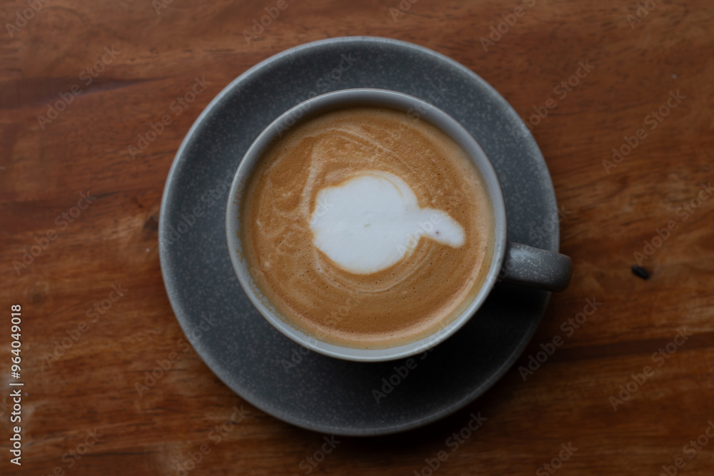 A cup of coffee, hot Latte, lace on the wooden table with a natural background. A cup of coffee, hot Latte, lace on the wooden table with a natural background.