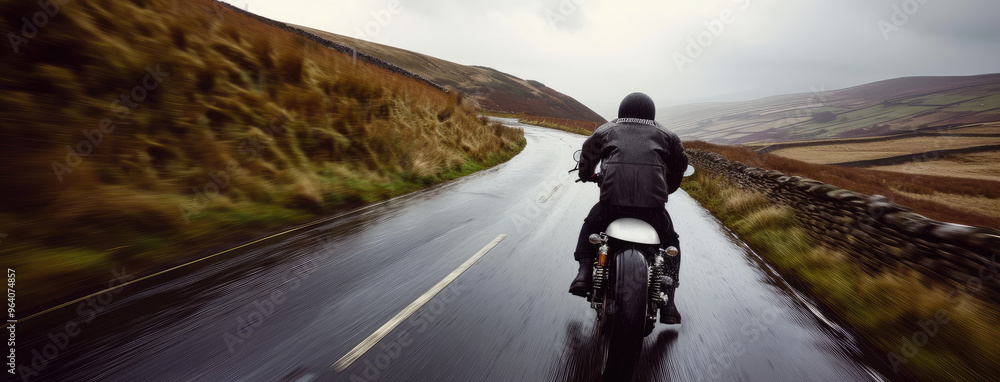 Obraz premium Motorcyclist on a Wet Countryside Road Adventure