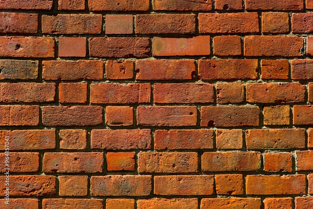 Fototapeta premium Close-up of a weathered brick wall, showcasing a variety of warm tones and textures.