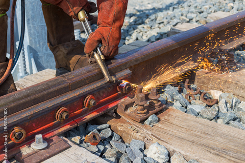 Operator performing cutting with oxygen and acetylene on a railway track.
