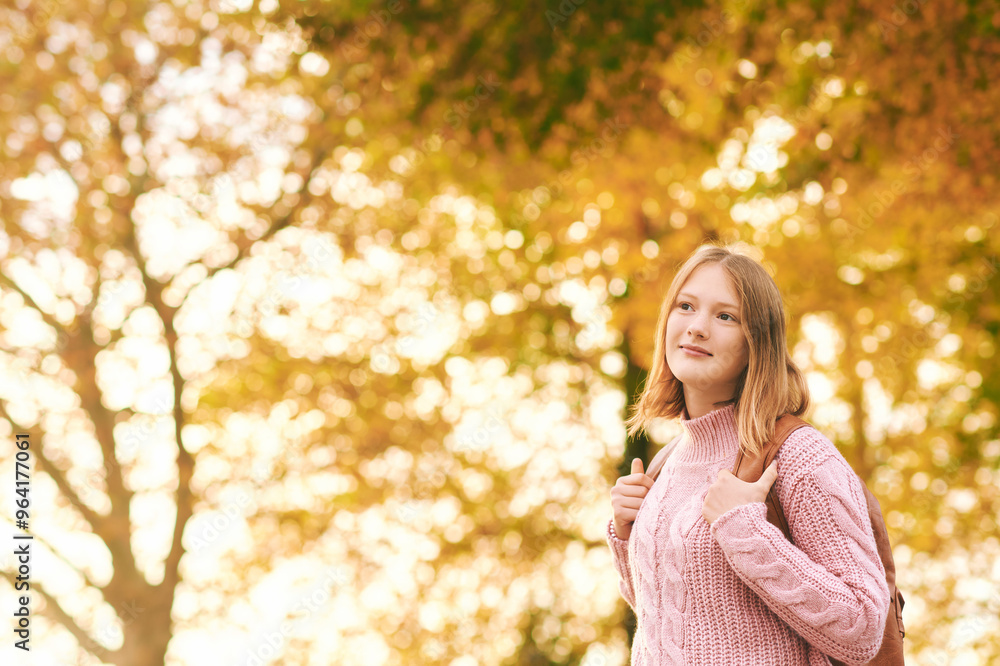 Aurumn portrait of friendly teenager girl posing outdoors with yellow foliage background, wearing backpack Aurumn portrait of friendly teenager girl posing outdoors with yellow foliage background, wearing backpack