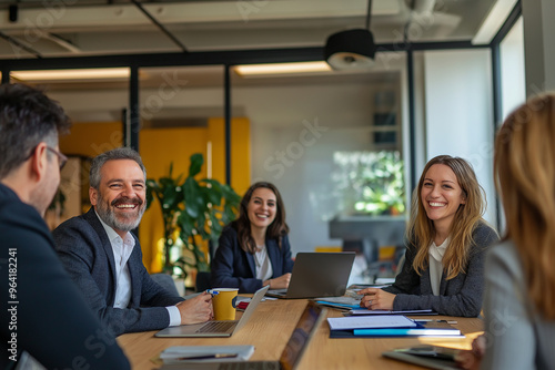 A group of people are sitting around a table in a conference room