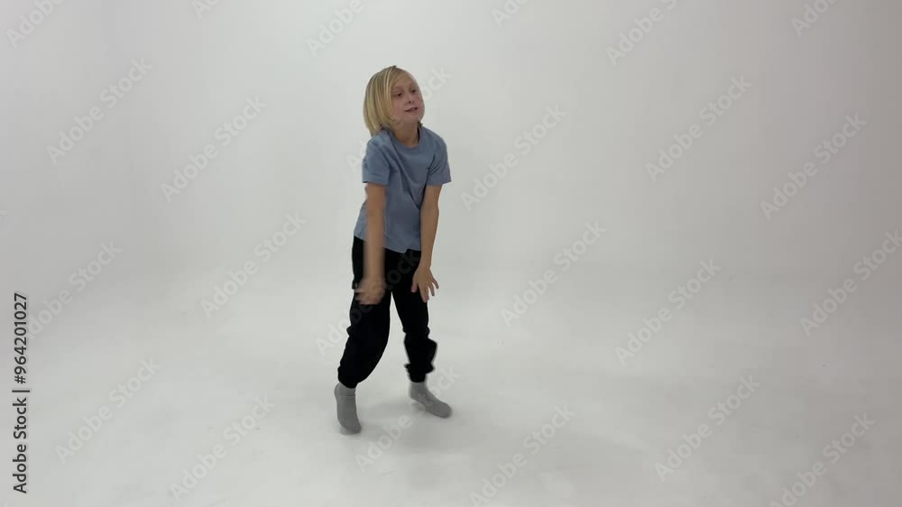 Young boy with blond hair practices a modern dance routine in a bright studio, showcasing energy and creativity Young boy with blond hair practices a modern dance routine in a bright studio, showcasing energy and creativity