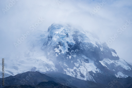 The snow-capped volcano Antisana located between the provinces of PIchincha and Napo in Ecuador with blue sky and white clouds. Landscape in Ecuador 