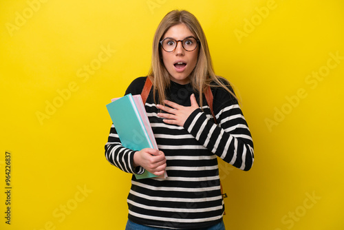 Young student woman isolated on yellow background background surprised and shocked while looking right