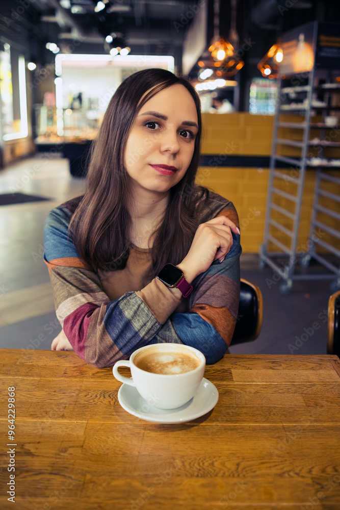 Morning Muse: A Womans Coffee Delight. A woman with long brown hair sits at a cozy coffee shop table, enjoying a cup of coffee. Morning Muse: A Womans Coffee Delight. A woman with long brown hair sits at a cozy coffee shop table, enjoying a cup of coffee.