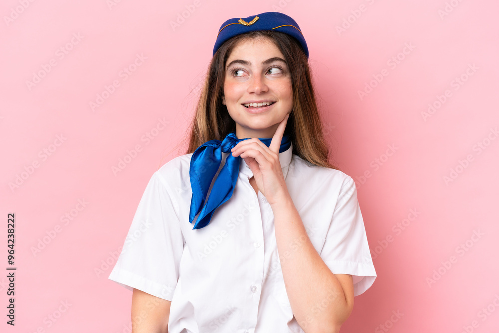 Airplane stewardess caucasian woman isolated on pink background thinking an idea while looking up Airplane stewardess caucasian woman isolated on pink background thinking an idea while looking up