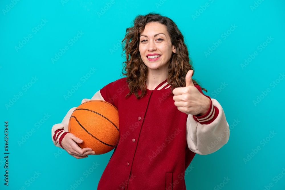 Young caucasian basketball player woman isolated on blue background with thumbs up because something good has happened Young caucasian basketball player woman isolated on blue background with thumbs up because something good has happened