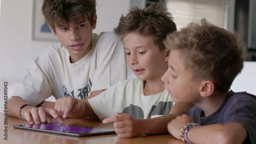 Three boys are gathered around a tablet, sharing laughter as they interact with the screen. Their expressions convey happiness and excitement in a warm, inviting space. Three boys are gathered around a tablet, sharing laughter as they interact with the screen. Their expressions convey happiness and excitement in a warm, inviting space.
