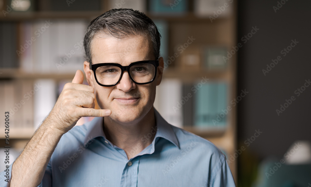 Smiling businessman doing the phone gesture Smiling businessman doing the phone gesture