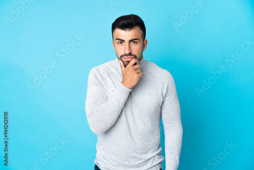 Obraz na płótnie Caucasian man over isolated blue background thinking