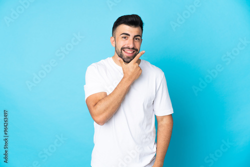 Caucasian man over isolated blue background happy and smiling