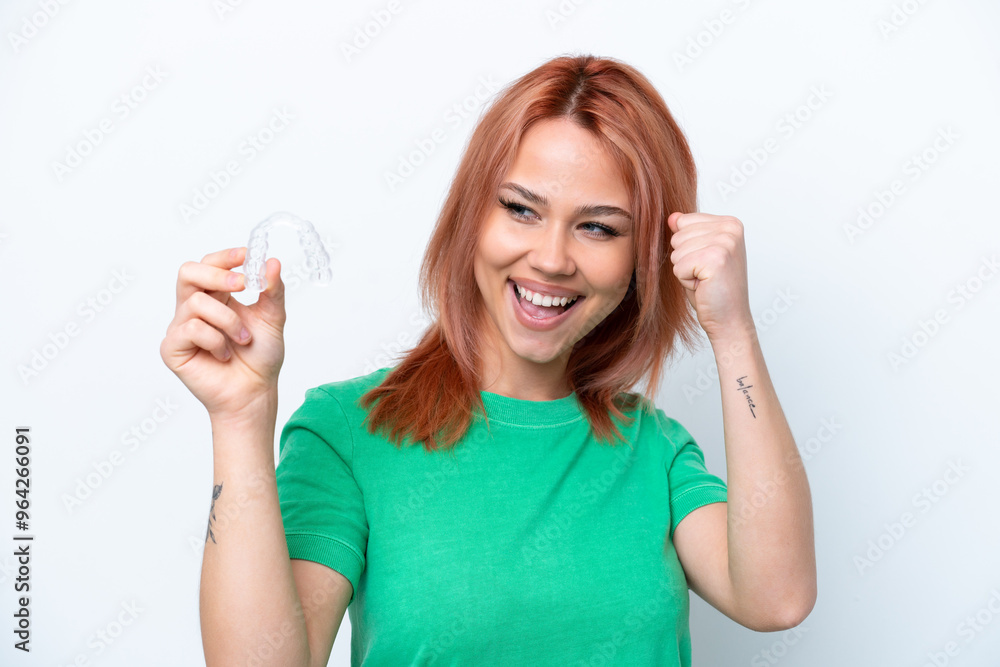 Young Russian girl holding invisible braces isolated on white background celebrating a victory