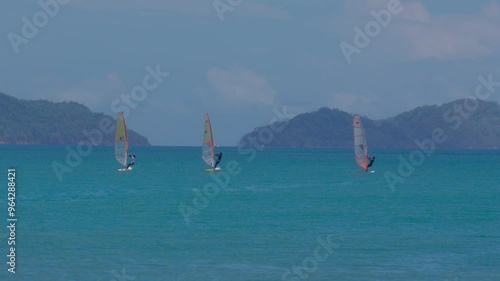 Windsurfers play with the wind and ocean waves photo