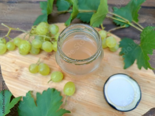 Syrop z winogron w słoiku otoczony gronami owoców photo