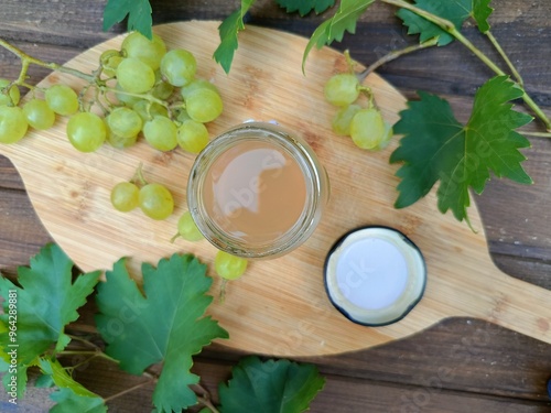 Syrop z winogron w słoiku otoczony gronami owoców photo