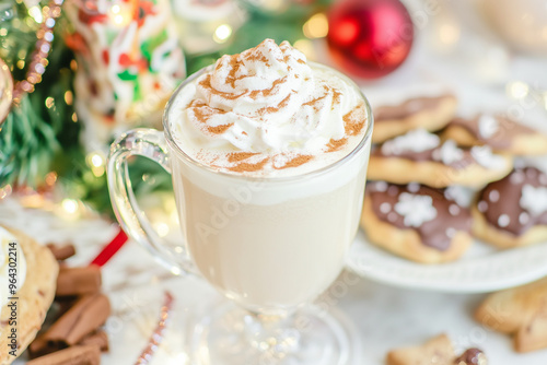 Close-up of traditional eggnog in a glass mug with whipped cream and cinnamon, surrounded by holiday cookies and festive table settings