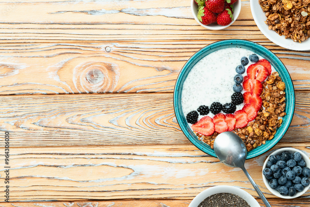 Healthy breakfast . Yogurt with berries ( strawberry , raspberry , blueberry , blackberry ) , granola and chia seeds . Top view Healthy breakfast . Yogurt with berries ( strawberry , raspberry , blueberry , blackberry ) , granola and chia seeds . Top view