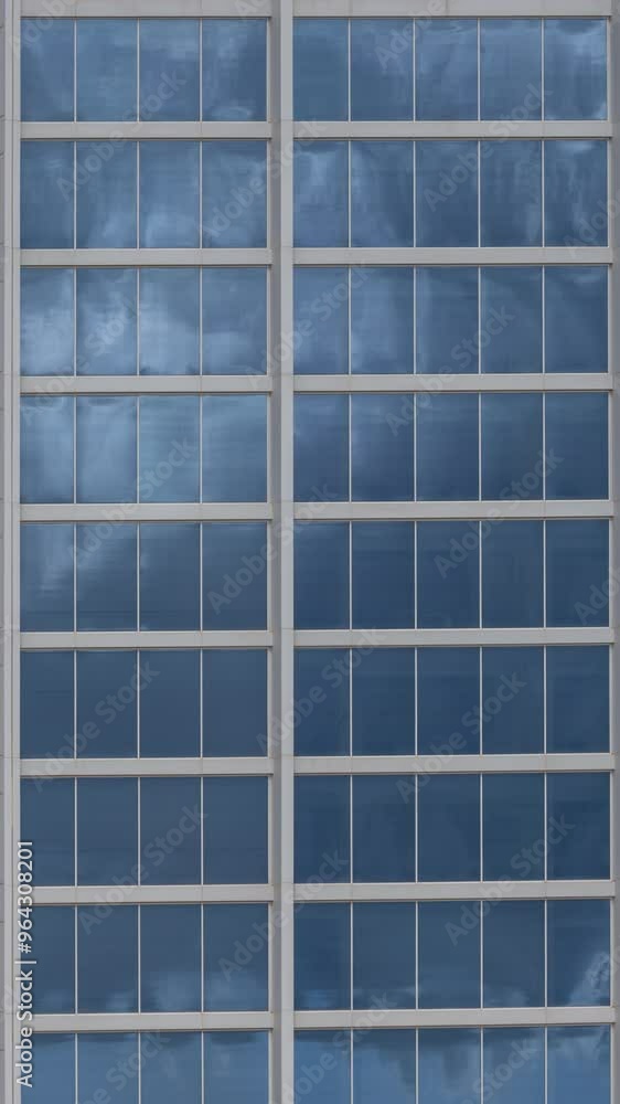 Clouds passing in reflection of glass windows of skyscraper Clouds passing in reflection of glass windows of skyscraper