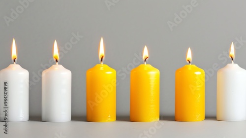 A row of yellow and white candles burning.